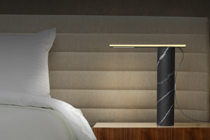 luxury hotel room setting with bed, pillows, bedside table and lamp